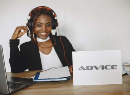 Smiling Woman with an "Advice" Sign Sitting in Front of Her